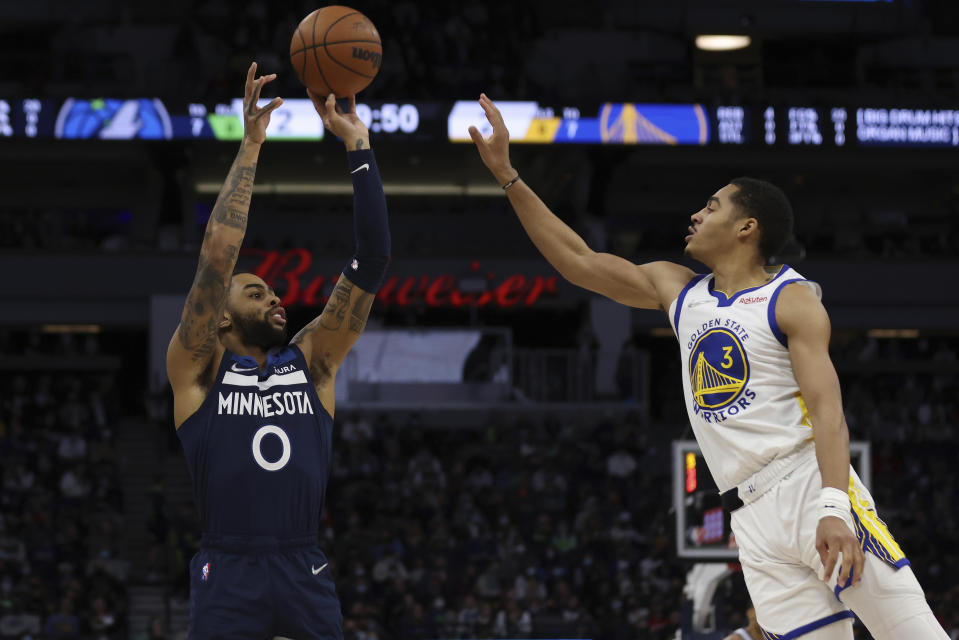 Minnesota Timberwolves guard D'Angelo Russell (0) shoots against Golden State Warriors guard Jordan Poole (3) during the first half of an NBA basketball game Sunday Jan. 16, 2022, in Minneapolis. (AP Photo/Stacy Bengs)