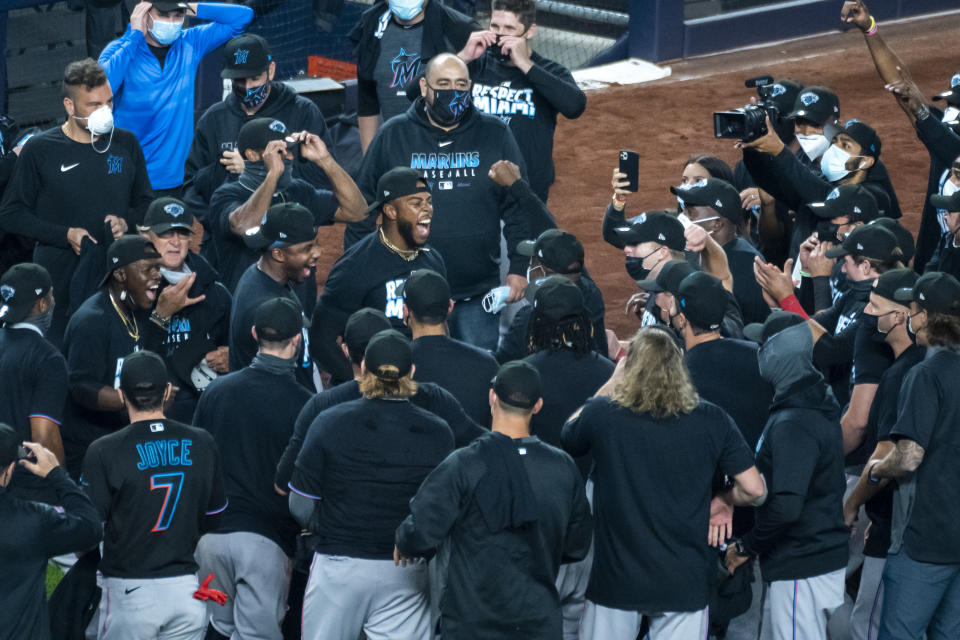 The Miami Marlins celebrate clinching a playoff berth after their win in the 10th inning of a baseball game against the New York Yankees at Yankee Stadium, Friday, Sept. 25, 2020, in New York. (AP Photo/Corey Sipkin)