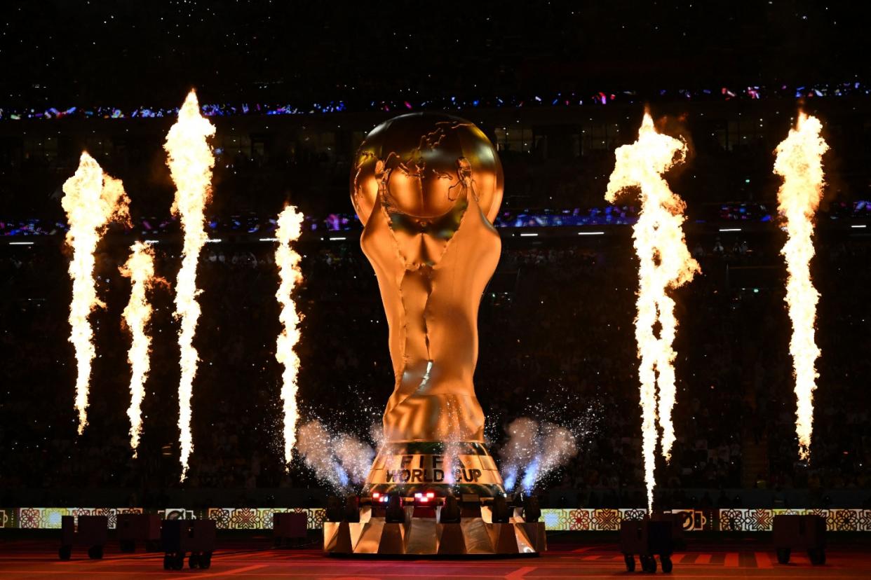 TOPSHOT - Fireworks explode around a replica of the FIFA World Cup trophy during the opening ceremony ahead of the Qatar 2022 World Cup Group A football match between Qatar and Ecuador at the Al-Bayt Stadium in Al Khor, north of Doha on November 20, 2022. (Photo by RAUL ARBOLEDA/AFP via Getty Images)