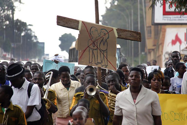 Activistas contra los homosexuales marchan por las calles de Kampala con pancartas el 11 de agosto de 2014 para manifestarse contra la ley contra los homosexuales recientemente anulada por el tribunal constitucional de Uganda