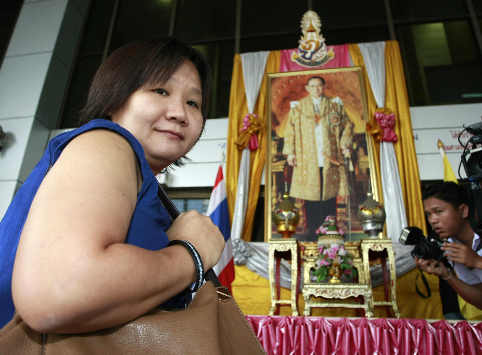 Chiranuch Premchaiporn, director of Prachatai website, walks past a portrait of King Bhumibol Adulyadej at the criminal court in Bangkok, Thailand Wednesday, May 30, 2012. A Thai court sentenced Chiranuch to an eight-month suspended sentence for failing to act quickly enough to remove Internet posts deemed insulting to Thailand's royalty. (AP Photo/Apichart Weerawong)