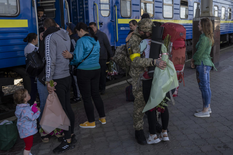 Two couples kiss during their reunion after three months of war-related separation at the Kharkiv train station in eastern Ukraine, Friday, May 27, 2022. (AP Photo/Bernat Armangue)