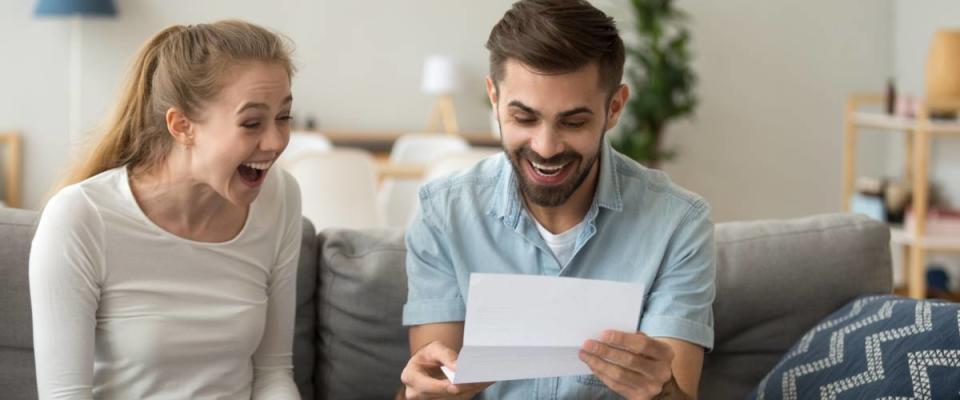 Couple happy looking at bills