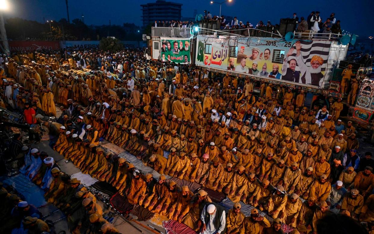 Supporters of Islamic political party Jamiat Ulema-e-Islam held evening prayers during Friday's anti-government protests - AFP