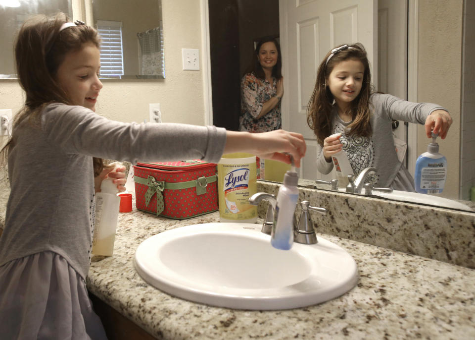 In this Saturday, Feb. 8, 2014 photo, Lily Cherry, 8, cleans her bathroom as her mother, Andrea, supervises at their home in Kingwood, Texas. Cherry has passed on her childhood practice of doing chores to her own children believing it gives them a sense of family responsibility. (AP Photo/Pat Sullivan)