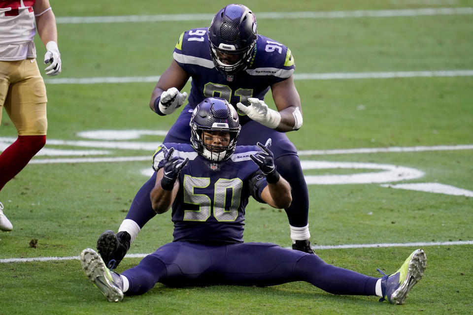 Seattle Seahawks outside linebacker K.J. Wright (50) and defensive end L.J. Collier (91) celebrate a defensive stop against the San Francisco 49ers during the first half of an NFL football game, Sunday, Jan. 3, 2021, in Glendale, Ariz. (AP Photo/Ross D. Franklin)