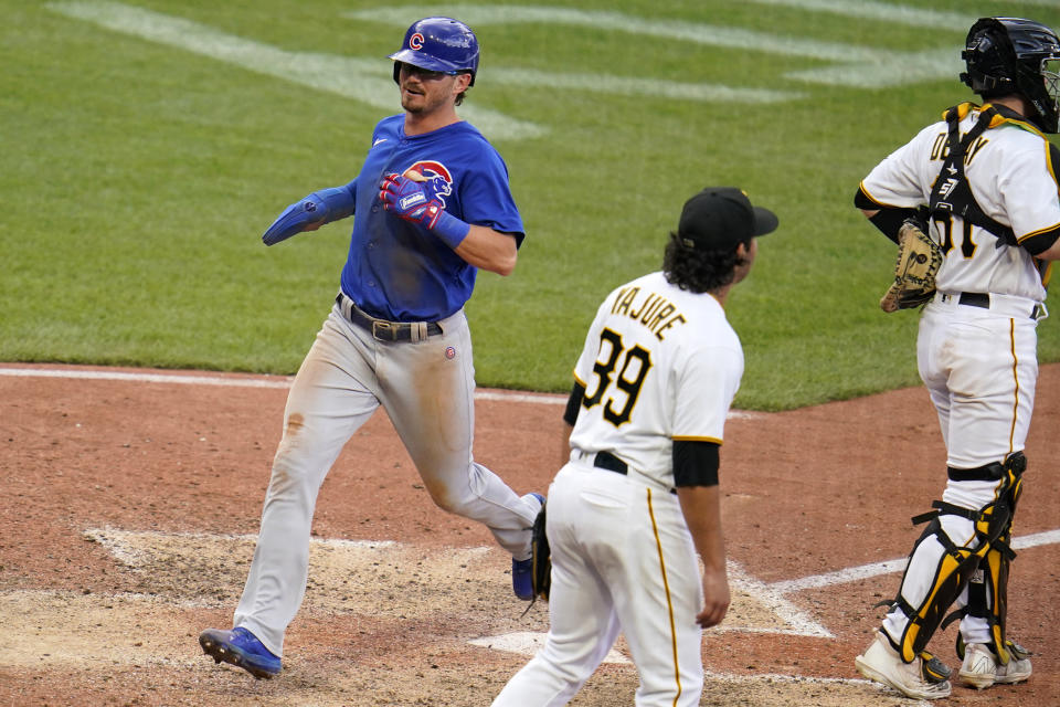 Chicago Cubs' Zach McKinstry, left, scores on a wild pitch by Pittsburgh Pirates starting pitcher Miguel Yajure (89) during the eighth inning of a baseball game in Pittsburgh, Sunday, Sept. 25, 2022. (AP Photo/Gene J. Puskar)