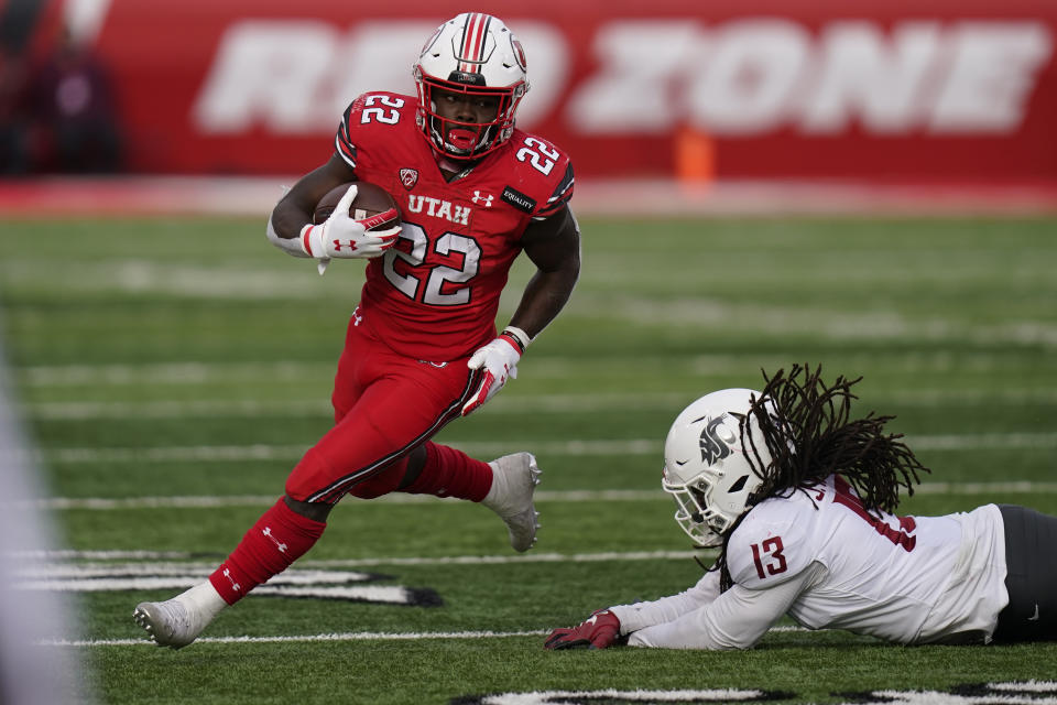 FILE - In this Dec. 19, 2020, file photo, Utah running back Ty Jordan (22) runs for a score as he eludes a tackle by Washington State linebacker Jahad Woods (13) during the second half of an NCAA college football game in Salt Lake City. Jordan was selected as the PAC-12 newcomer of the year. (AP Photo/Rick Bowmer, File)