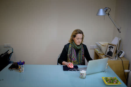 Psychologist Teresa Diaz Bada, daughter of Carlos Diaz Arcocha who was killed by armed Basque separatists ETA in 1985, works in her office, alongside a picture of her father, in San Sebastian, Spain, April 30, 2018. Picture taken April 30, 2018. REUTERS/Vincent West