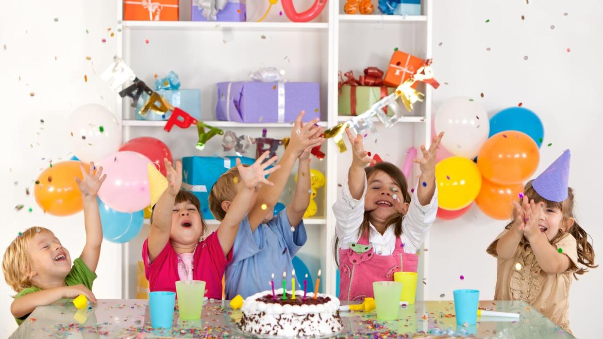 happy group of children catching confetti at birthday party