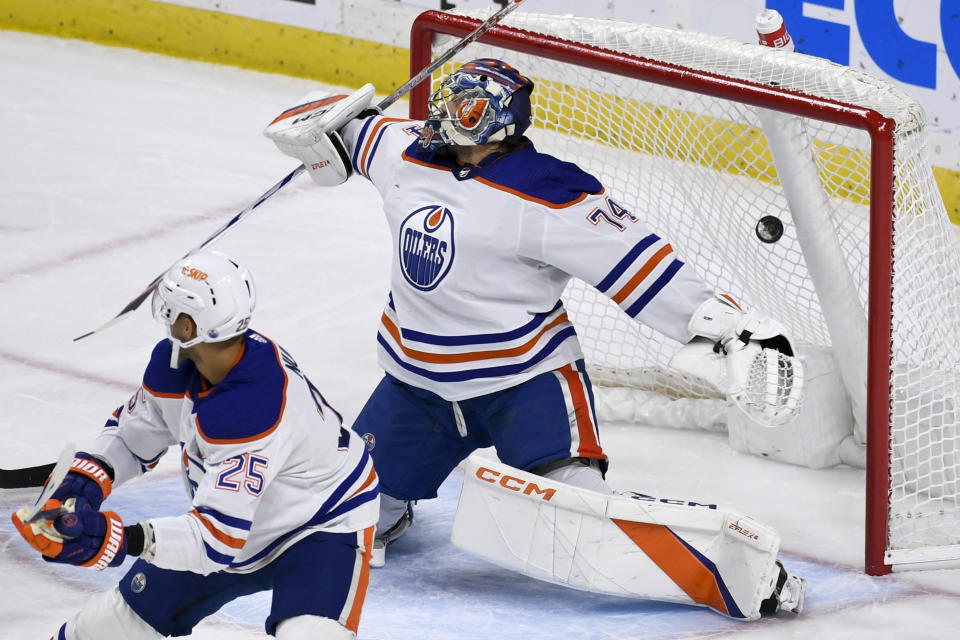 Edmonton Oilers goalie Stuart Skinner (74) lets a puck hit by Minnesota Wild left wing Matt Boldy (not shown) get by him for a goal as Oilers defenseman Darnell Nurse (25) looks on during the first period of an NHL hockey game Monday, Dec. 12, 2022, in St. Paul, Minn. (AP Photo/Craig Lassig)