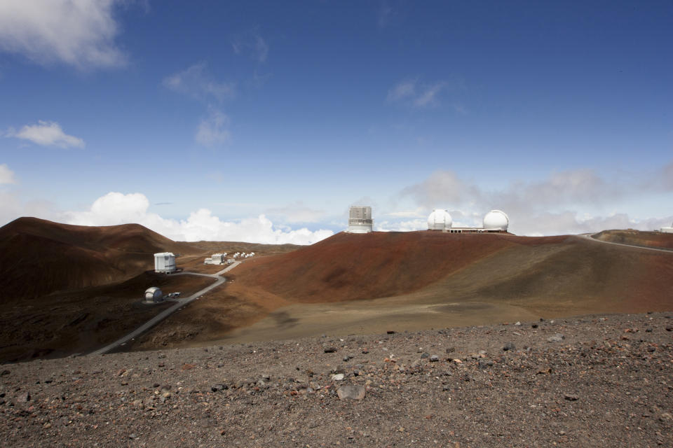 FILE - This Aug. 31, 2015, file photo shows telescopes on the summit of Mauna Kea on Hawaii's Big Island. An agreement has been reached for a giant telescope to be built in Spain's Canary Islands if it cannot be put atop a Hawaii mountain. Telescope builder TMT International Observatory says Hawaii's Mauna Kea remains the preferred location for the $1.4 billion Thirty Meter Telescope. (AP Photo/Caleb Jones, File)