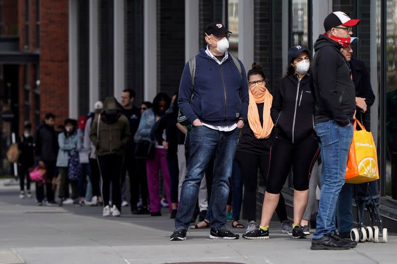 People cover their faces as they wait to enter a grocery store in Washington