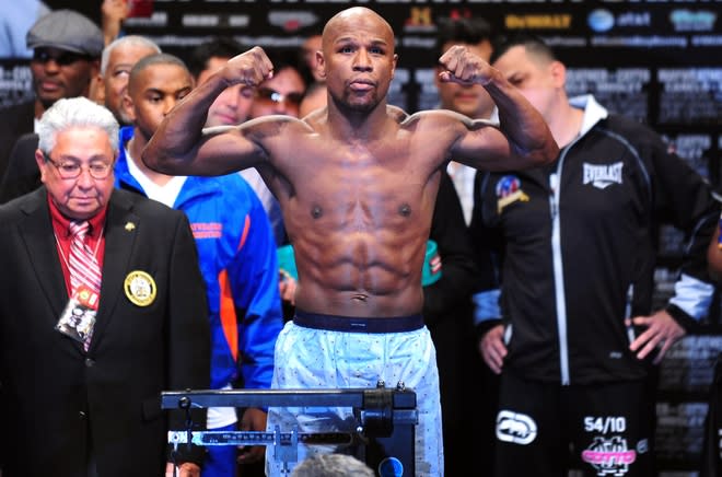 US boxer Floyd Mayweather gestures on the scales during the weigh-in on May 4, 2012 in Las Vegas, Nevada ahead of the Super Welterweight championship fight against Puerto Rico's Miguel Cotto on May 5. AFP PHOTO/Frederic J. BROWNFREDERIC J. BROWN/AFP/GettyImages