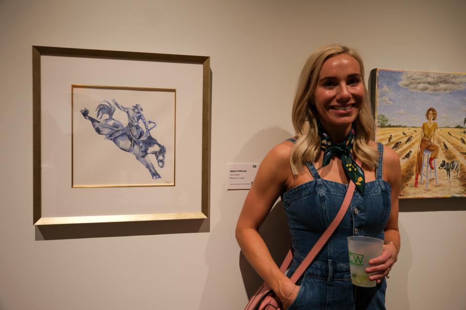 Bekah McWhorter stands by her painting "Local Legend" at the 20x20 Art Exhibition and Silent Auction at the Amarillo Museum of Art on the campus of Amarillo College.