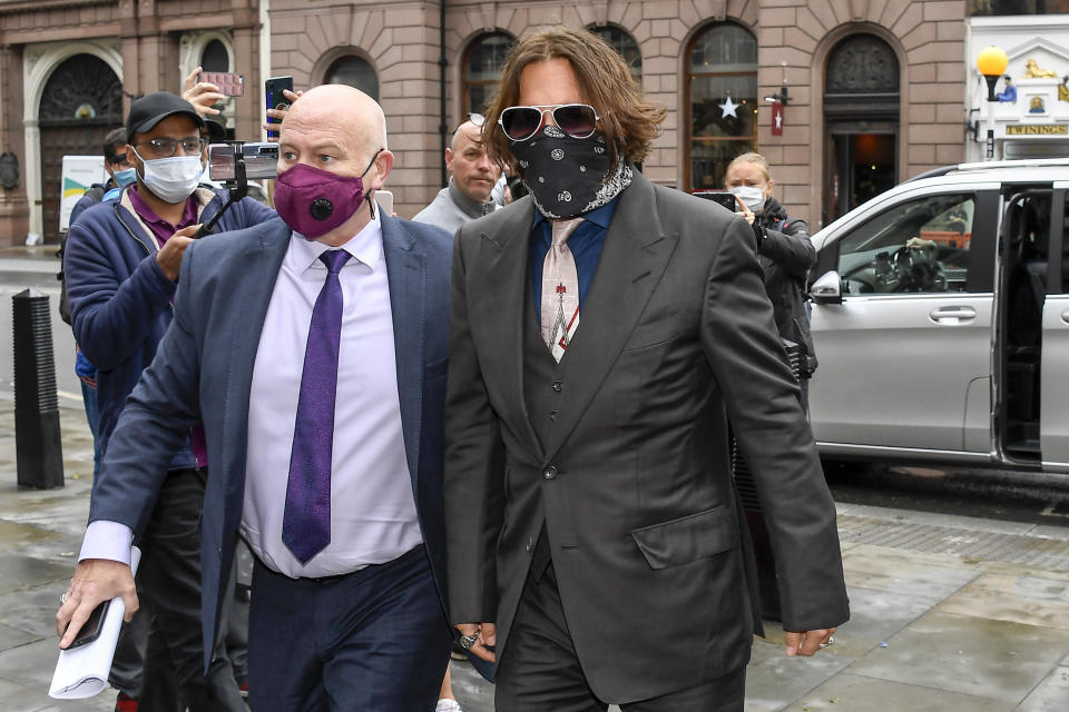 Johnny Depp, a la derecha, llega al Alto Tribunal en Londres el miércoles 8 de julio de 2020. El astro de Hollywood fue interrogado por segundo día consecutivo por abogados del tabloide británico The Sun, al que acusa de difamación por haberlo llamado un "marido golpeador" en un artículo publicado en abril de 2018. (AP Foto/Alberto Pezzali)