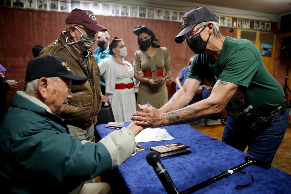 Louis Moore, left, shakes hand with Thomas Christner, right.