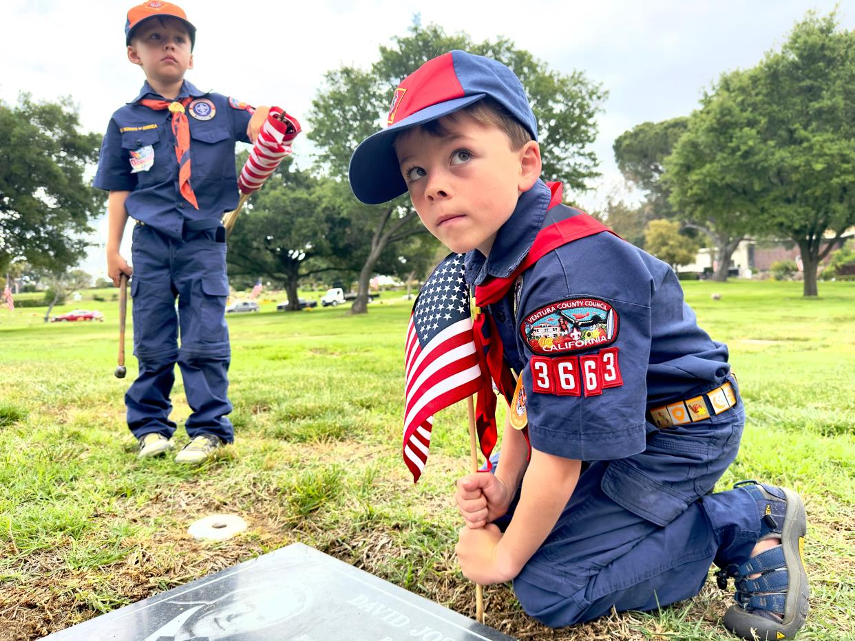 In this file photo, Blake Thomas, 5, left, watches as his brother Jack Thomas, 7, places an American flag at Pierce Brothers Valley Oaks-Griffin Memorial Park in Westlake Village May 27. The brothers joined members of Cub Scout Pack 3663 of Simi Valley to adorn veterans' graves with flags ahead of Memorial Day.
