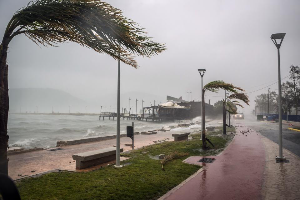 Waves break on a seaside tavern during a storm at the port of Argostoli, on the Ionian island of Kefalonia, western Greece, Friday, Sept. 18, 2020. A powerful tropical-like storm named Ianos battered the western islands of Zakynthos, Kefalonia, and Ithaki overnight, causing flash flooding, property damage, power outages, and road closures mostly from downed trees, police and local authorities said. (AP Photo/Nikiforos Stamenis)