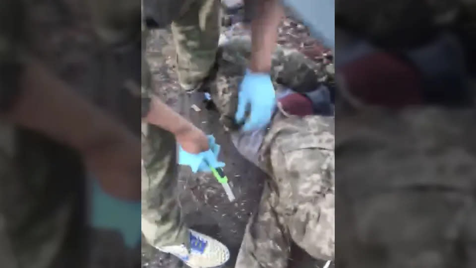 A screenshot from the video which appears to show Russian soldiers castrating a Ukrainian soldier. (Telegram)