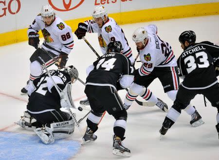 May 24, 2014; Los Angeles, CA, USA; Los Angeles Kings defenseman Willie Mitchell (33) and left wing Dwight King (74) help goalie Jonathan Quick (32) defend the goal against Chicago Blackhawks right wing Patrick Kane (88), center Jonathan Toews (19) and left wing Bryan Bickell (29) in game three of the Western Conference Final of the 2014 Stanley Cup Playoffs at Staples Center. Mandatory Credit: Gary A. Vasquez-USA TODAY Sports