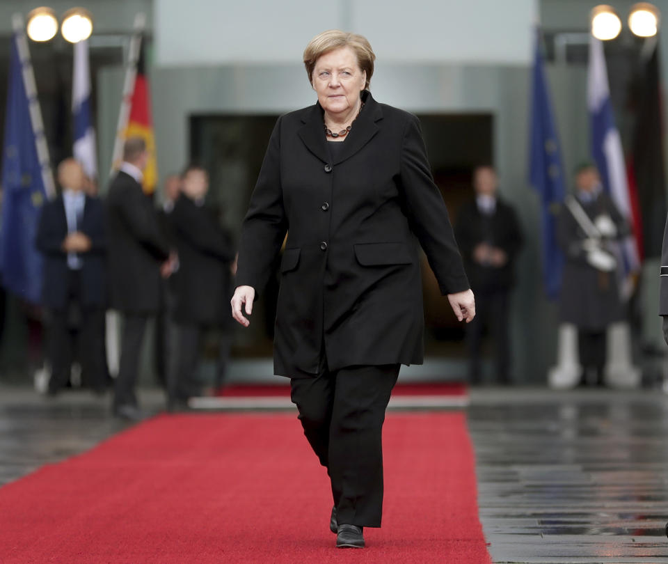 German Chancellor Angela Merkel walks on the red carpet prior to a meeting with Sanna Marin, Prime Minister of Finland, at the chancellery in Berlin, Germany, Wednesday, Feb. 19, 2020. (AP Photo/Michael Sohn)