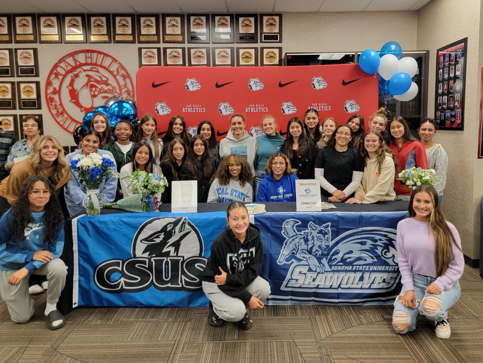 Oak Hills' Takoah Castillo and Alyssa Vernon, sitting from left to right, pose for a photo with teammates after signing a National Letter of Intent on Wednesday afternoon to continue their soccer careers.