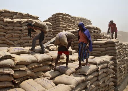 Labourers unload sacks filled with wheat from a truck at the Punjab State Civil Supplies Corporation Limited (PUNSUP) godown at a wholesale grain market in Punjab, India, May 6, 2015. REUTERS/Ajay Verma