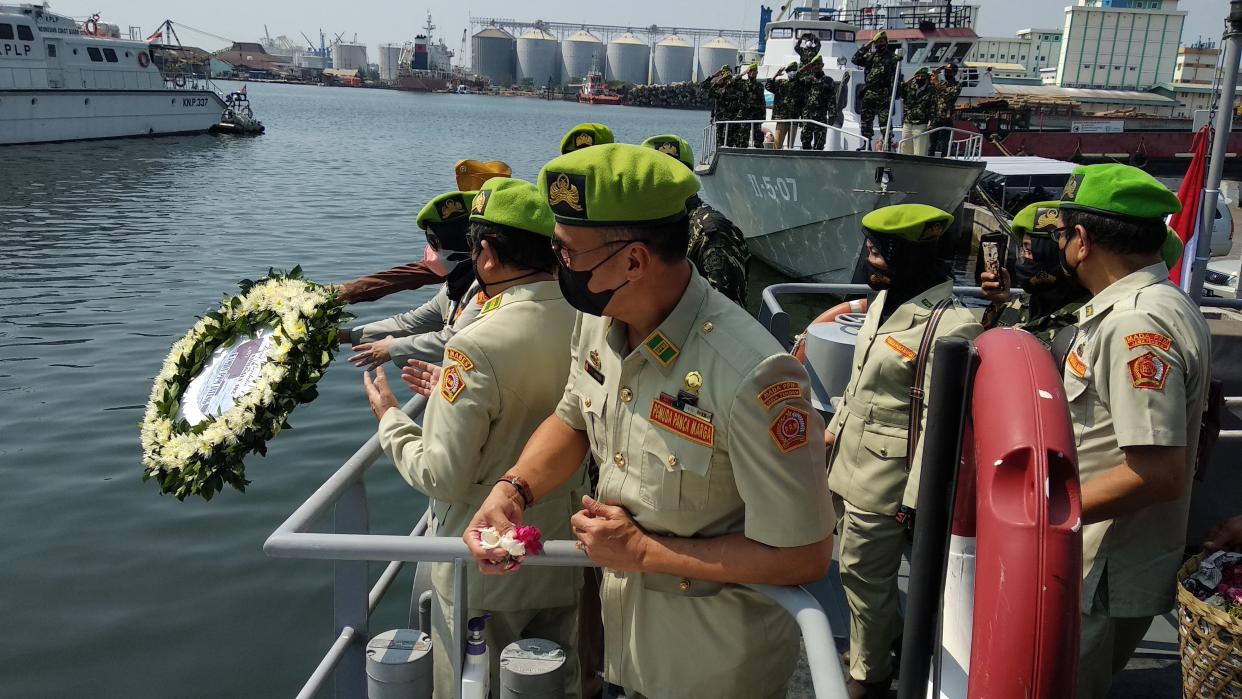 Naval officers throw a flower garland into the sea at the port of Semarang on April 26, as sign of respect for the submarine that disappeared off the coast of Bali and has been found cracked into pieces on the seafloor with all 53 crew killed in the disaster. 