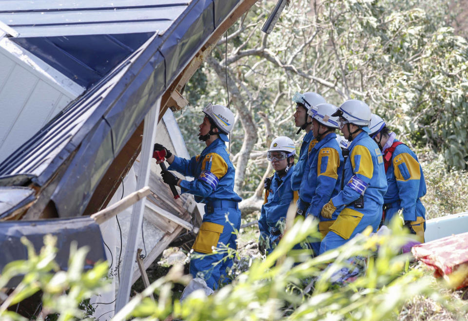 Police search for missing persons around a house destroyed by a landslide after an earthquake in Atsuma town, Hokkaido, northern Japan, Thursday, Sept. 6, 2018. Several people were reported missing in the nearby the town, where a massive landslide engulfed homes in an avalanche of soil, rocks and timber. (Masanori Takei/Kyodo News via AP)