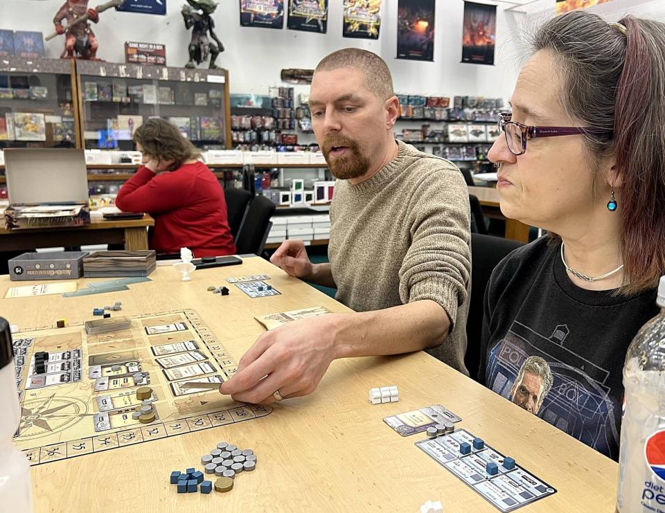 Clark Pease, left, and Carol Toczylowski play "Age of Civilization" during Erie Board Games' weekly board game night at Gateway Games on Jan. 25.