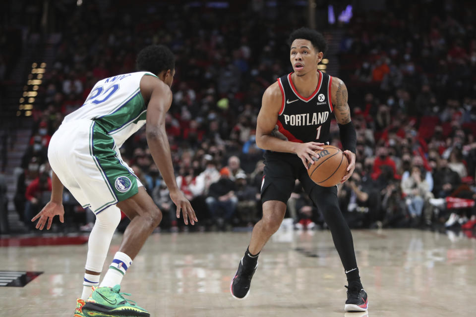 Dallas Mavericks Brandon Knight, left, guards against Portland Trail Blazers guard Anfernee Simons during the first half of an NBA basketball game in Portland, Ore., Monday, Dec. 27, 2021. (AP Photo/Amanda Loman)