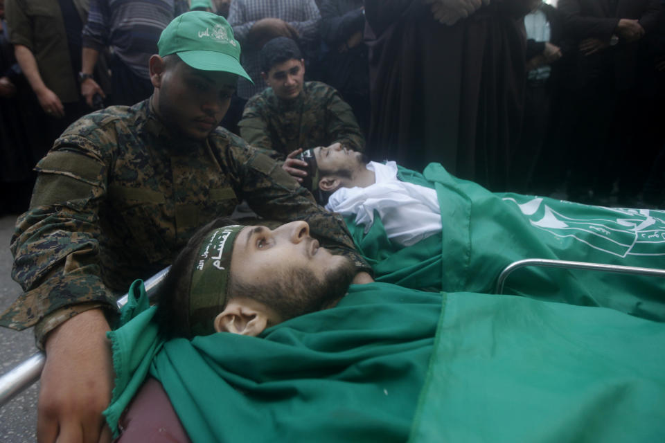 Hamas fighters mourn next the bodies of their comrades who were killed after gunfire erupted last Sunday during a Hamas-organized funeral in a tense Palestinian refugee camp, during their funeral procession in the southern port city of Sidon, Lebanon, Tuesday, Dec. 14, 2021. (AP Photo/Mohammed Zaatari)