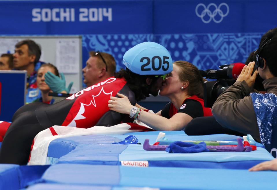 Canada's Charles Hamelin kisses his girlfriend and compatriot speed skater Marianne St-Gelais after winning the men's 1,500 metres short track speed skating race finals at the Iceberg Skating Palace during the 2014 Sochi Winter Olympics February 10, 2014. REUTERS/David Gray (RUSSIA - Tags: OLYMPICS SPORT SPEED SKATING)