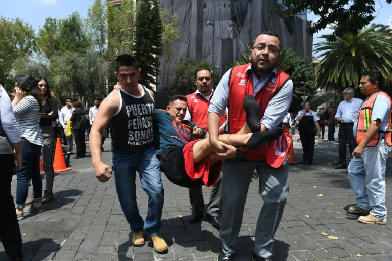 An injured man is carried away by rescuers in Mexico City