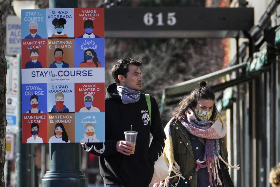 A sign in multiple languages encourages citizens to wear face coverings to help prevent the spread of COVID-19, Tuesday, Nov. 17, 2020, in Portland, Maine. (AP Photo/Robert F. Bukaty)