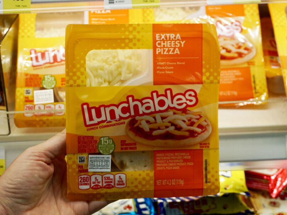katie lockhart holding lunchable pizza flavor in bangkok grocery store