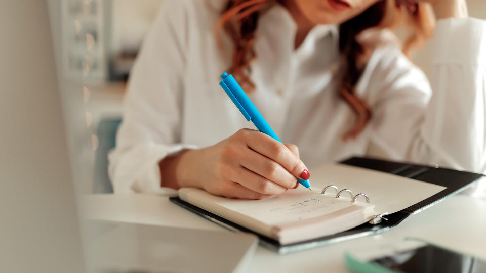 Cropped shot of a businesswoman making notes at her desk in a modern office.