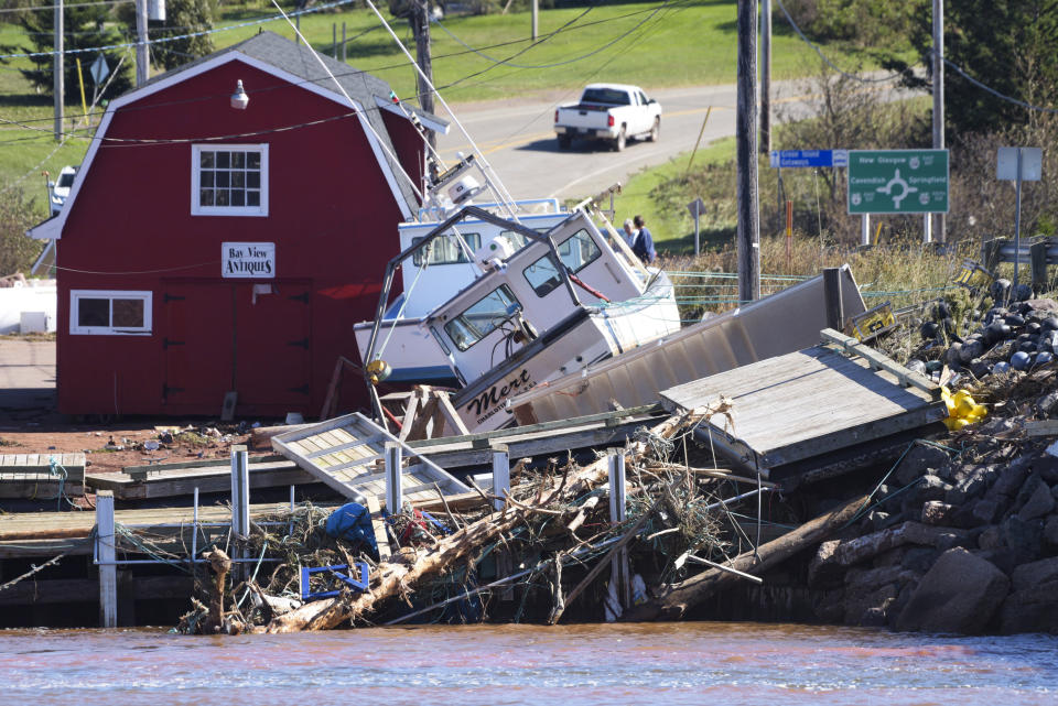 A boat lies on debris at the wharf in Stanley Bridge, Prince Edward Island, on Sunday, Sept. 25, 2022. After hammering Atlantic Canada, post-tropical storm Fiona has moved inland in southeastern Quebec, with Environment Canada saying the storm will continue to weaken as it tracks across southeastern Labrador and over the Labrador Sea. (Brian McInnis/The Canadian Press via AP)