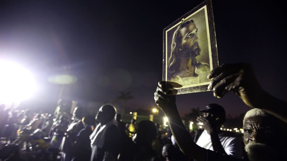 A survivor holds the Warner Sallman image of Jesus Christ during services on February 12, 2010, in Port-au-Prince, Haiti, after an earthquake devastated the country. - Mario Tama/Getty Images