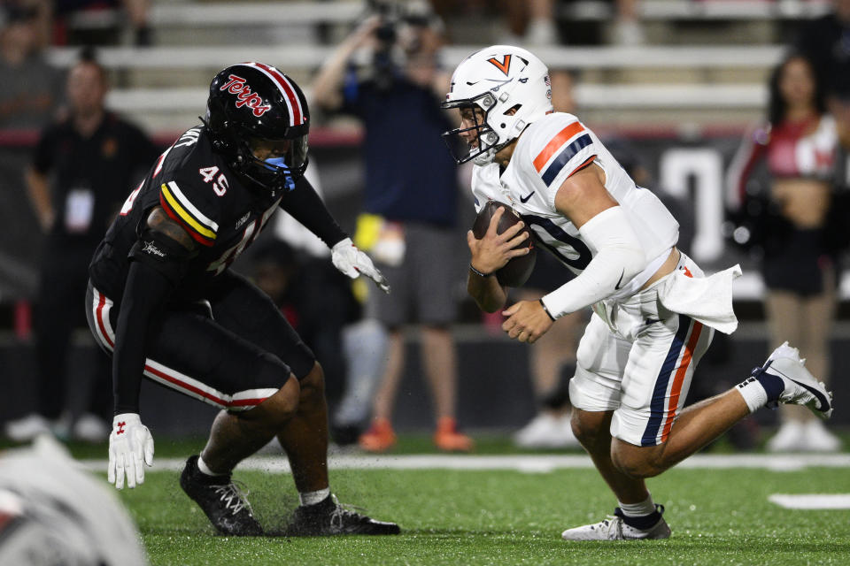 Virginia quarterback Anthony Colandrea, right, runs with the ball against Maryland linebacker Kellan Wyatt (45) during the first half of an NCAA college football game Friday, Sept. 15, 2023, in College Park, Md. (AP Photo/Nick Wass)