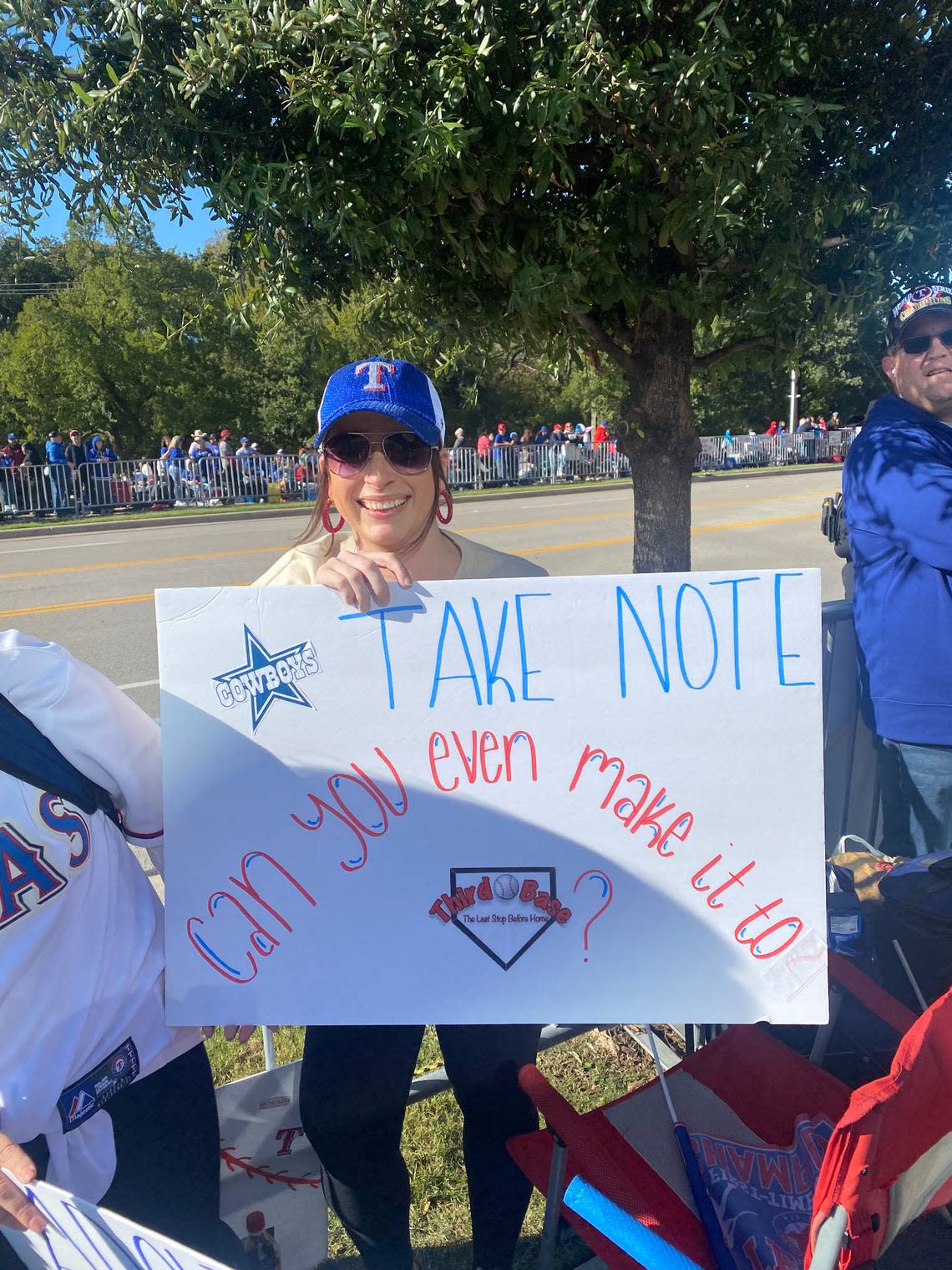 A Texas Rangers fan poses with a home-made sign before the World Series victory parade. Jenny Rudolph