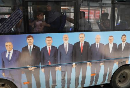 A woman sits in a bus carrying a posters of Turkish President Tayyip Erdogan's ruling AK Party (AKP) in Mardin, capital of Mardin province in southeastern Turkey, June 19, 2018. REUTERS/Goran Tomasevic