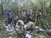 In this photo released by Colombia's Armed Forces Press Office, soldiers and Indigenous men tend to the four Indigenous brothers who were missing after a deadly plane crash, in the Solano jungle, Caqueta state, Colombia, Friday, June 9, 2023. Colombian President Gustavo Petro said Friday that authorities found alive the four children who survived a small plane crash 40 days ago and had been the subject of an intense search in the Amazon jungle. (Colombia's Armed Force Press Office via AP)