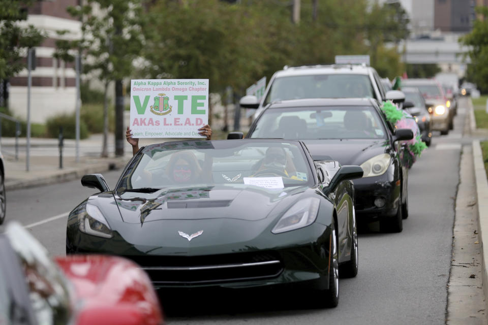 People participate in a "Parade to the Polls" event, organized by Operation Go Vote!, a collaborative of African American civic and social organizations, in New Orleans, Saturday, Oct. 24, 2020. In the best of times, it’s a massive logistical challenge to get millions out to vote. In 2020, the difficulty has been dramatically compounded: by fear of the coronavirus, by complications and confusion over mail-in ballots, by palpable anxiety over the bitter divisions in the country. (AP Photo/Rusty Costanza)