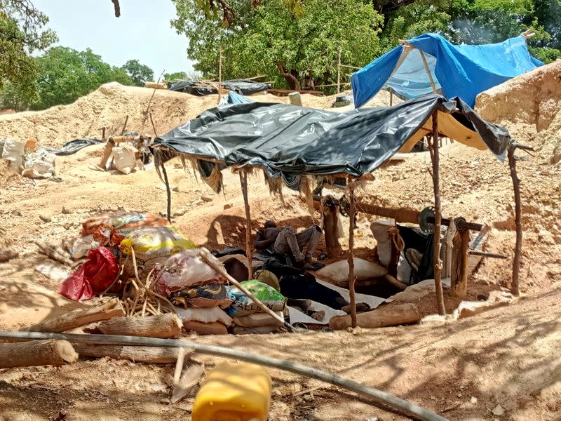 Informal gold miners are seen taking a break from work under the midday sun at an artisanal mining site near Dano