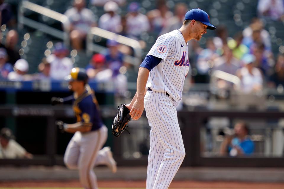 New York Mets starting pitcher Jacob deGrom, left, reacts as Milwaukee Brewers' Jace Peterson runs the bases after hitting a home run during the fifth inning of the first baseball game of a doubleheader, Wednesday, July 7, 2021, in New York. (AP Photo/Frank Franklin II)