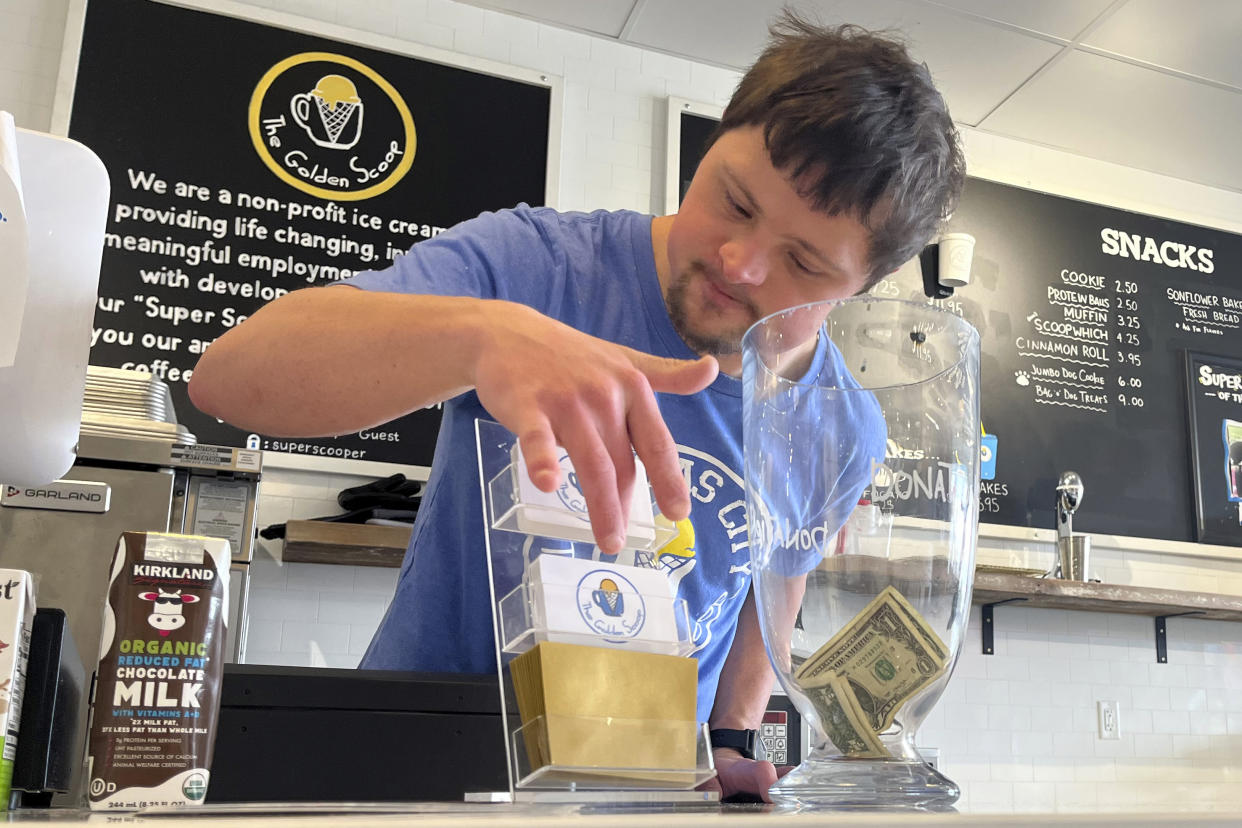 Patrick Chapman, 27, prepares for customers Thursday, March 2, 2023, at The Golden Scoop, an Overland Park, Kan., ice cream and coffee shop that employs workers with developmental disabilities, paying them more than minimum wage. But some disabled workers employed at so-called sheltered workshops are earning far less than minimum wage, an issue that has captured the attention of lawmakers in the state. Disability rights advocates say the practice is discriminatory and more than a dozen states have banned such wages. (AP Photo/Heather Hollingsworth)