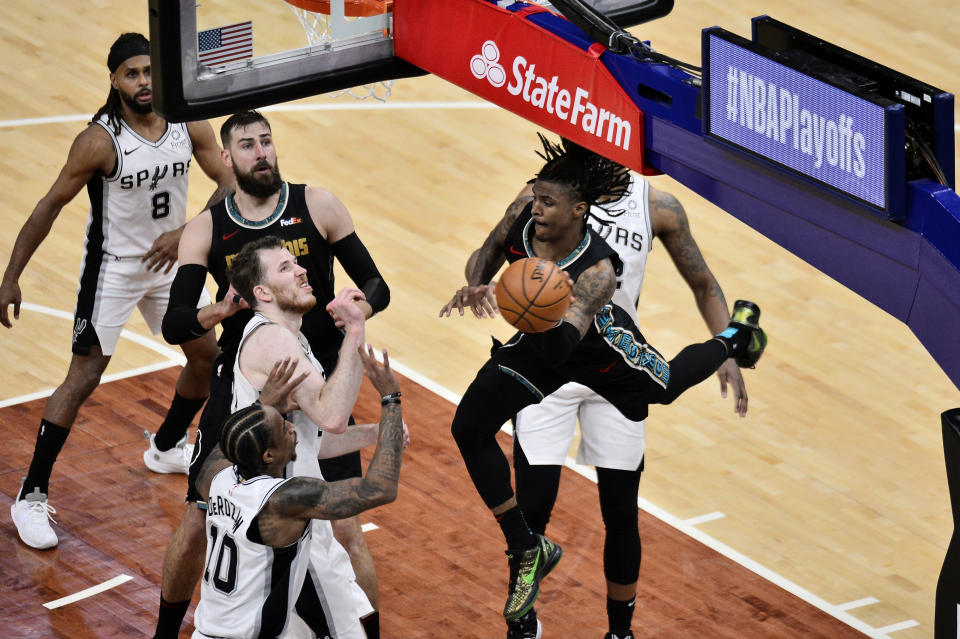 Memphis Grizzlies guard Ja Morant looks to pass the ball over San Antonio Spurs forward DeMar DeRozan (10) during the second half of an NBA basketball Western Conference play-in game Wednesday, May 19, 2021, in Memphis, Tenn. (AP Photo/Brandon Dill)