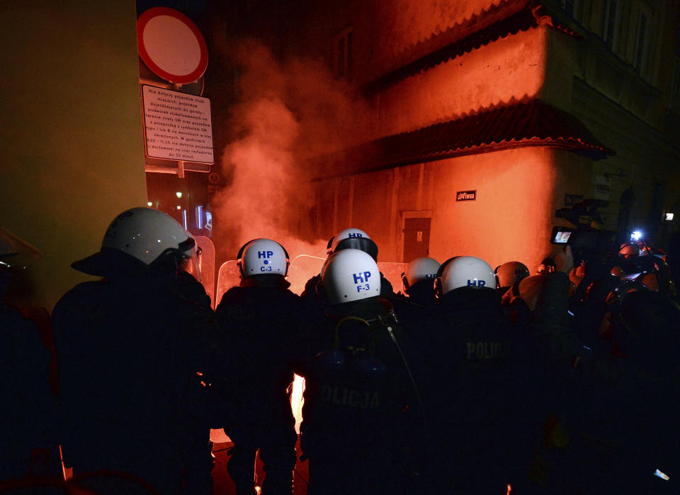 Police separate a far-right group from a protest against the conservative government on the eighth straight day of angry demonstrations that were triggered by a recent tightening of the abortion law, in the Old Town, in Warsaw, Poland, Friday, Oct. 30, 2020.(AP Photo/Czarek Sokolowski)